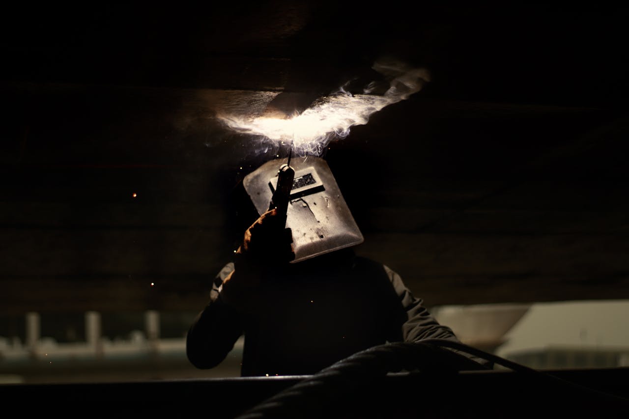 Mastering the First Impression: Your intriguing post title goes here A silhouette of a welder in action, creating sparks in a dark industrial setting.