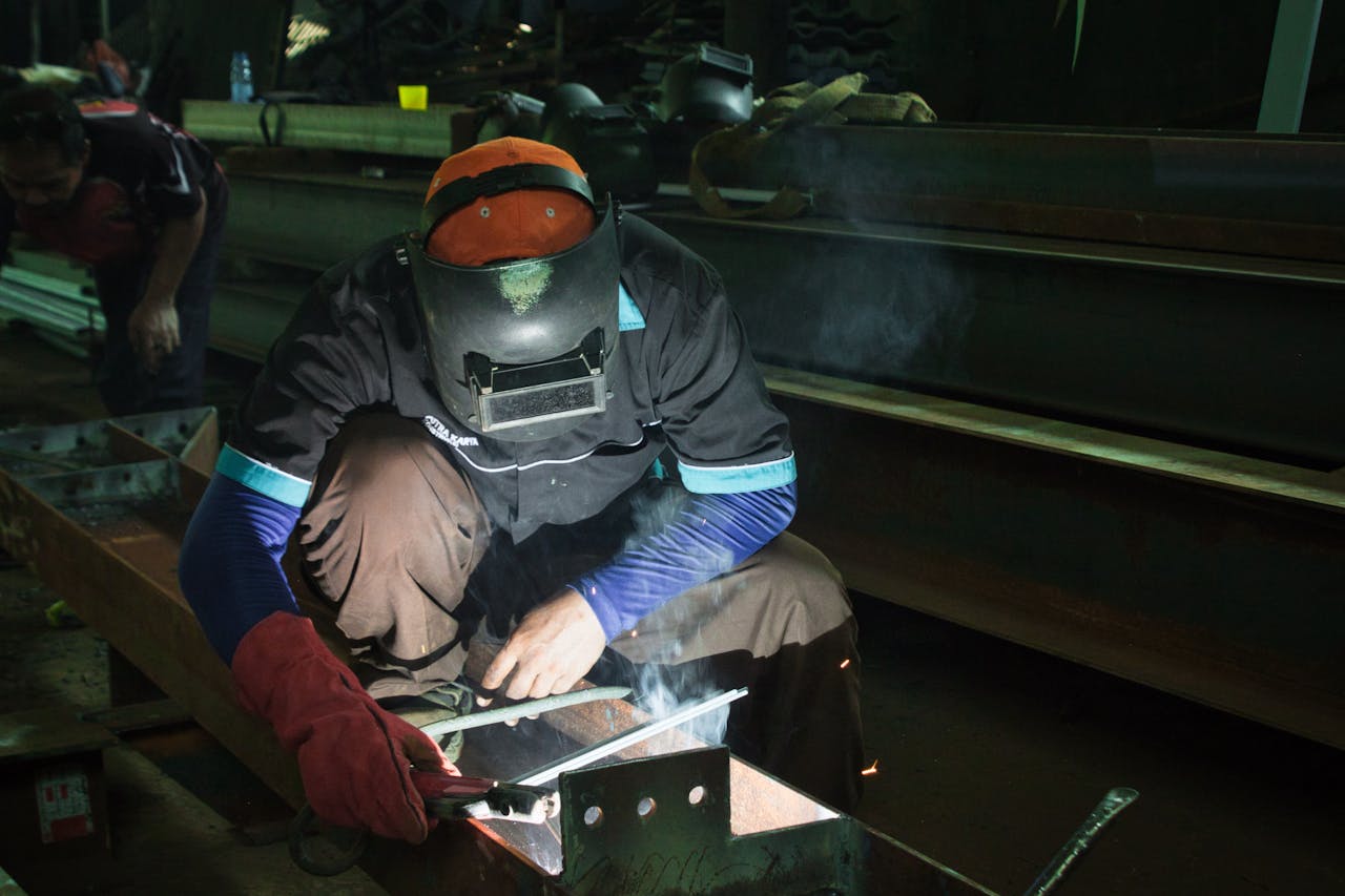 services-01 A skilled welder working on metal structures in a Jakarta workshop, showcasing precision and safety protocols.